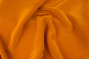 Golden silk or satin luxury fabric texture can use as abstract background.