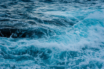 Closeup of sea waves with white foam. Natural marine texture
