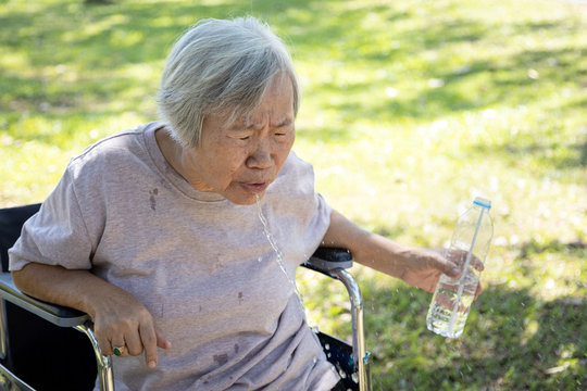 Asian senior woman choking on water,elderly people with poor quality water,bad smell and dirty of water, smelled plastic causing her to spitting out the water while drinking from plastic bottles
