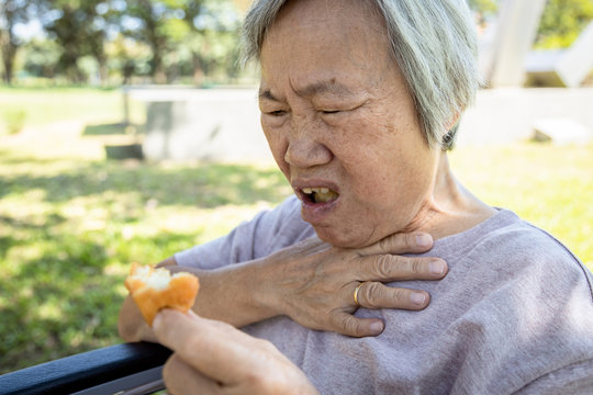 Asian senior woman suffers from choke and cough,clogged up food,elderly people choking during feeding,food might stuck in the throat and suffocate ,health problem, asphyxia,suffocation concept