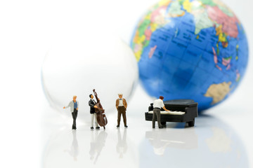 Miniature people : pianist playing piano and Violinist Man with mini world glass,playing musical instrument concept.
