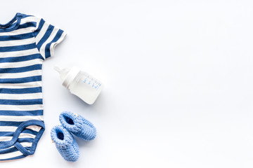 Baby background - blue color. Clothes and accessories for newborn boy on white table top-down frame copy space