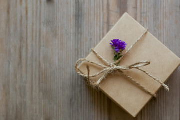 gift box with dry wild flowers on wooden background