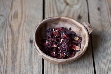 brown ceramic with karkade tea.  hibiscus flowers in ceramic bowl