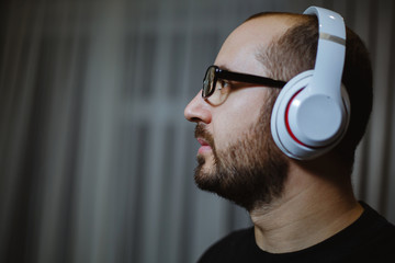 Handsome man listening to music in wireless headphones.Background texture.