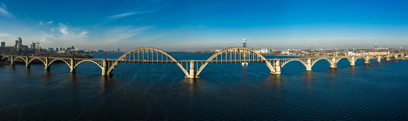 Aerial panoramic view on old arch railway Merefo-Kherson bridge across the Dnieper river in Dnepropetrovsk, Ukraine