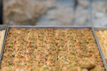 Kanafeh, a traditional Arabic dessert, special dough, with goat cheese, pistachio, almonds, nuts, butter, and honey. Old City, Jerusalem, Israel.