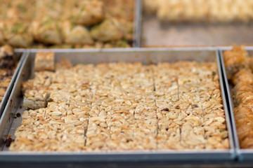Kanafeh, a traditional Arabic dessert, special dough, with goat cheese, pistachio, almonds, nuts, butter, and honey. Old City, Jerusalem, Israel.