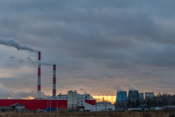 Fototapeta na wymiar Smoking factory chimneys against the sunset. Environmental pollution