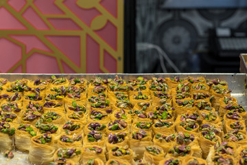 Kanafeh, a traditional Arabic dessert, special dough, with goat cheese, pistachio, almonds, nuts, butter, and honey. Old City, Jerusalem, Israel.
