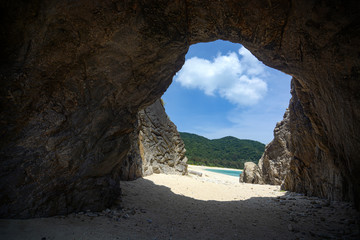 Rock tunnel entrance to Aharen Beach on the tropical island of Tokashiki in Okinawa, Japan