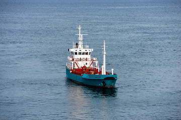small cargo ship carrying gas or petroleum in the fjords of norway