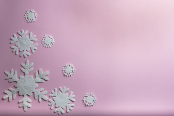 Christmas or winter composition. Pattern made of snowflakes on pastel pink background.
