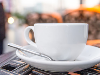 White coffee cup with saucer and teaspoon close-up