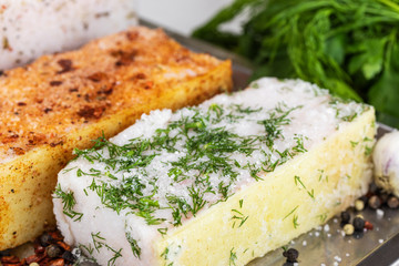 Two large pieces of salted lard with dill, parsley, paprika and a mixture of peppers