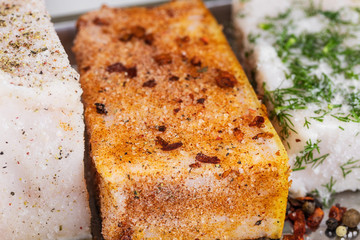 Three large pieces of salted lard with a mixture of peppers, paprika and dill