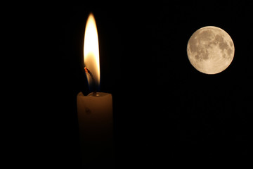 One light candle burning brightly in the black background