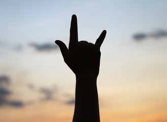 Silhouette hand of love at sunset.