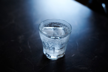 Gin Tonic Cocktail served with ice, on a black marble surface