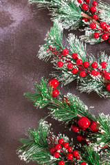 Christmas fir twigs with red berries on dark background