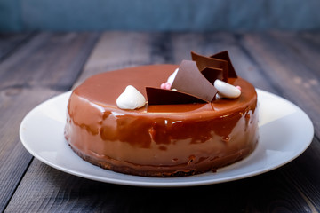 A large portion of a chocolate glossy cake with bright layers of chocolate souffle is presented.