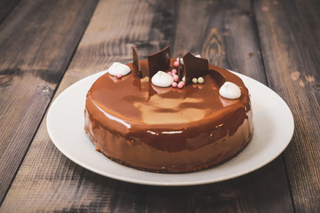 A large portion of a chocolate glossy cake with bright layers of chocolate souffle is presented.