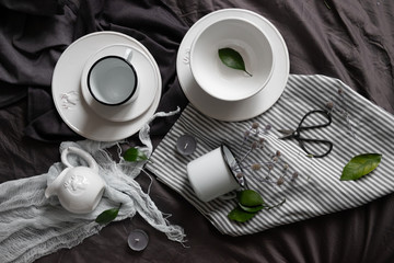 beautiful flat lay. dishes, green plants and candles, on a dark background.