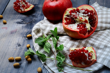 Red pomegranates, one broken and bright transparent grains visible