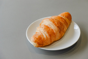 Fresh and tasty croissant on white plate