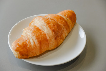 Fresh and tasty croissant on white plate