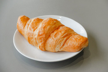 Fresh and tasty croissant on white plate