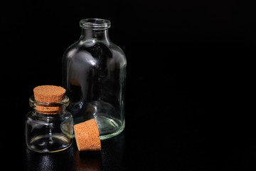 Small glass bottles with corks on a black background