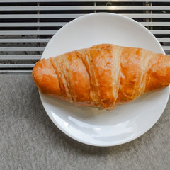 Fresh and tasty croissant on white plate