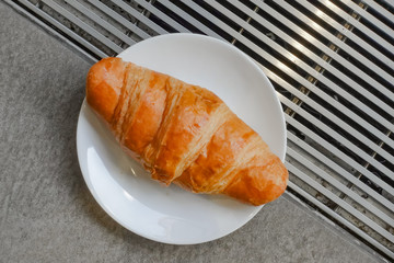 Fresh and tasty croissant on white plate