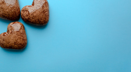 Valentine's flat lay with love chocolate gingerbread heart on colorful blue background, greeting card copy space top view. The celebration of Valentine's Day.