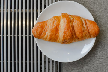 Fresh and tasty croissant on white plate