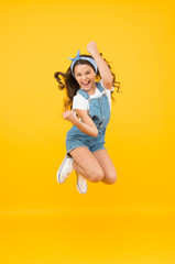 Fototapeta Active girl feel freedom. Fun and relax. feeling free. carefree kid on summer holiday. time for fun. retro beauty in mid air. Jump of happiness. small girl jump yellow background. full of energy. obraz