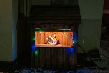 Christmas crib with baby dolls in a small wooden hut in front of a residential building in downtown Reykjavik.