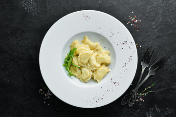 Dumplings with potatoes, butter and sour cream. Ukrainian traditional cuisine. Top view. Free space for your text.