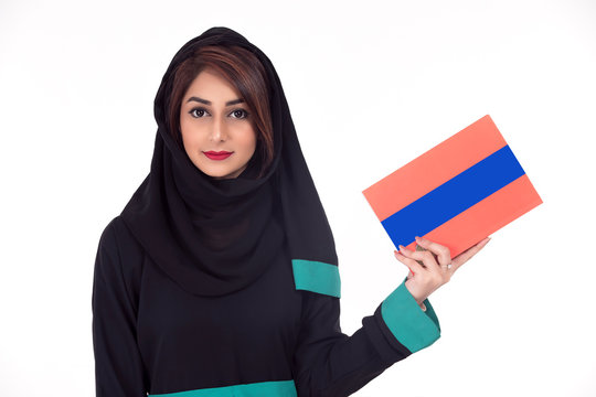 Arabic student wearing hijab and holding a book in her hand