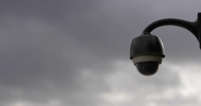 Footage of a surveillance cam on a buildings corner with gray clouds in the background...