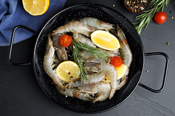 Flat lay composition with raw shrimps on black table