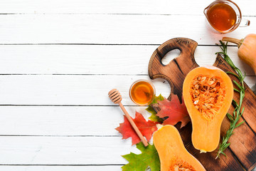 Fresh pumpkin with honey on white wooden background. Autumn food. Top view. Free copy space.