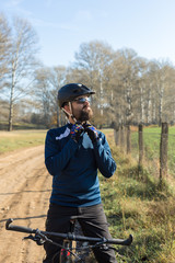 Cyclist in pants and fleece jacket on a modern carbon hardtail bike with an air suspension fork rides off-road.