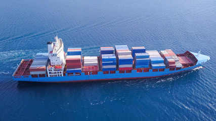 Large container ship at sea, loaded with various container brands. ULCV container ship sails on...