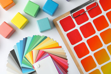 Color palettes and cubes on white background, top view