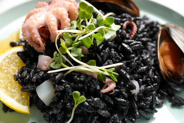 Delicious black risotto with seafood, closeup view