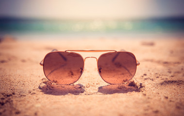 Fototapeta na wymiar Summer time sunglasses on the sand of jumeira beach, Dubai UAE