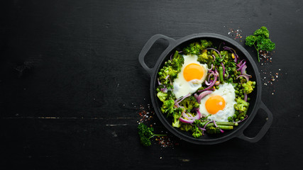 Vegetable Shakshuka in a pan. Fried eggs with vegetables: broccoli, green peas, beans, onions. Top view. Free space for your text.
