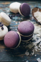 White and purple macarons or macaroons decorated with dry lavender flowers and coconut